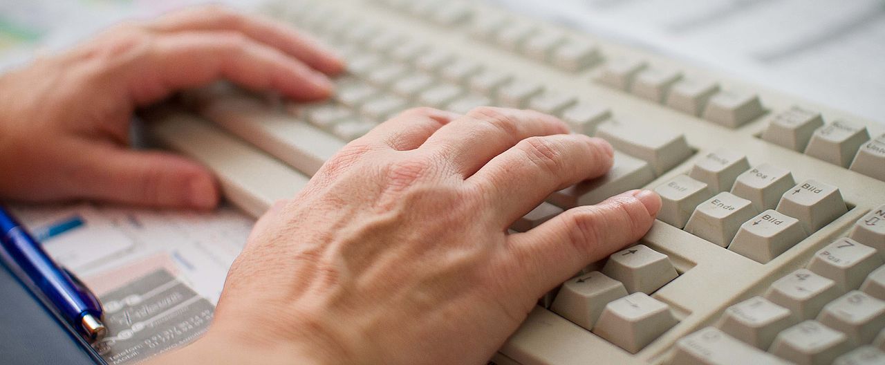 Hände schreiben auf Tastatur